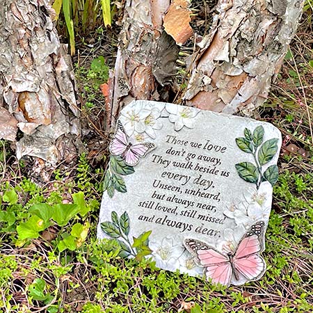 stepping stone with butterflies, inscribed with the words "Those we love don't go away, they walk beside us every day..." 